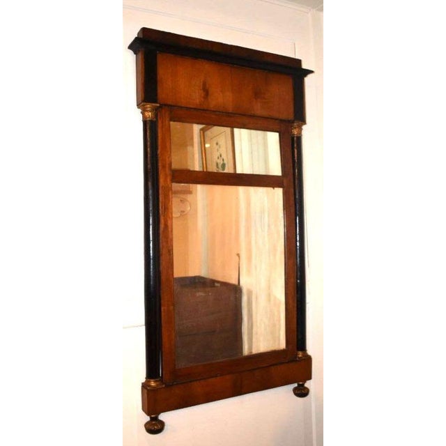 Late Continental Empire neoclassical mirror. Flanked by Corinthian capped columns and well grained mahogany hardwood...