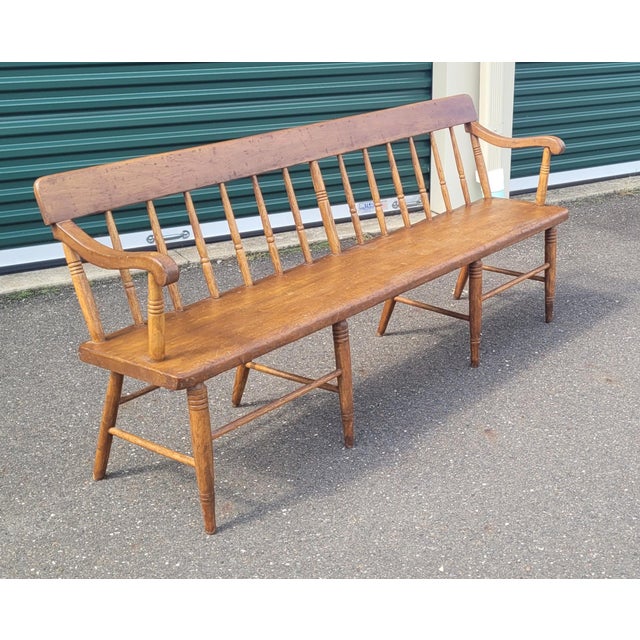 Circa 1840-1860 American antique deacons bench made of pine and elm. Features spindle back spindle legs rolled arms and...