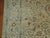 An oversize Persian Meshed rug with an all-over formal design on a tan field, an icy blue border, accent colors in red...