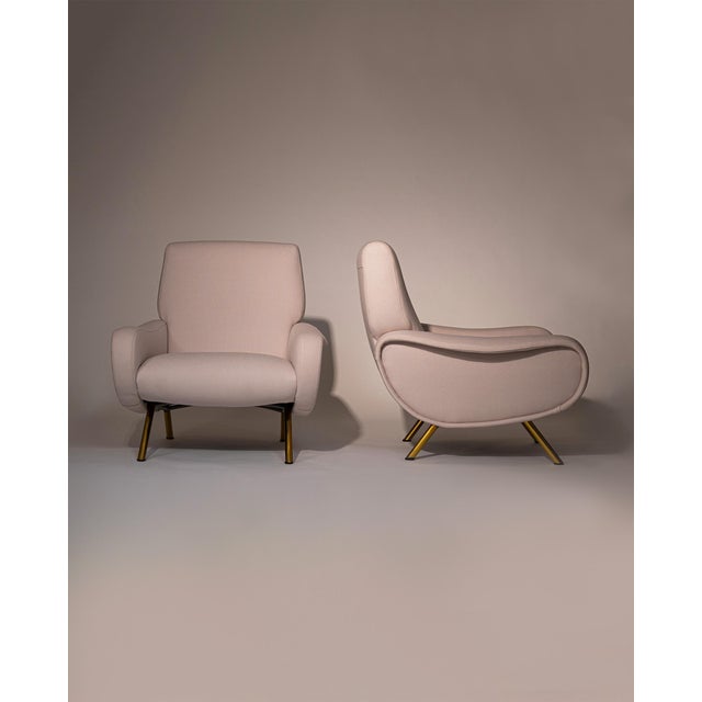 This elegant armchair features refined brass-plated legs and has been newly reupholstered in a soft white cream fabric by...