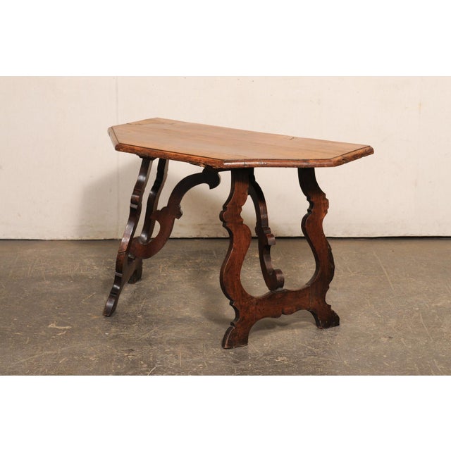 An Italian carved walnut table from the 18th century. This antique table from Italy features a demi-style halved-octagon...