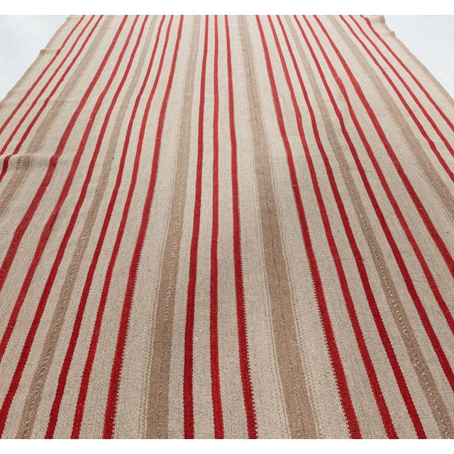 This striking mid-century Persian Kilim rug from 1955 is a compelling example of minimalist tribal craftsmanship. Woven...