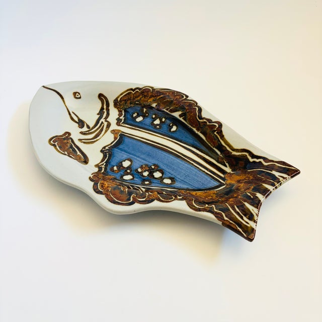 A large vintage studio pottery platter in the shape of a fish. Beautiful attention to detailing and hand painted designs....