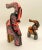 A pair of hand carved elephant sculptures of a large and small elephants. The miniature sculptures are carved off wood and...