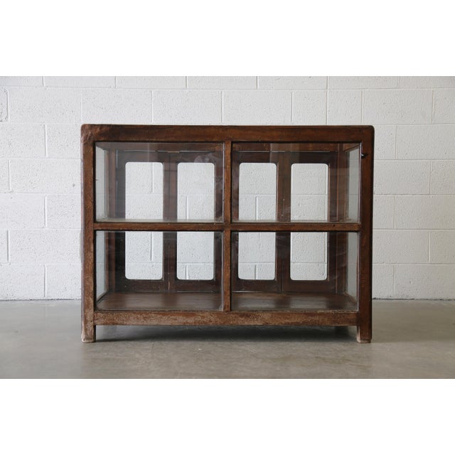 A Burmese teak store display cabinet imported from Indonesia. Great patina and primitive looks with original hardware...