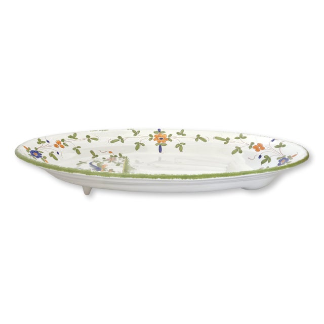 Early 20th century French faience serving platter featuring hand-painted floral decoration in vibrant blue, green, and...