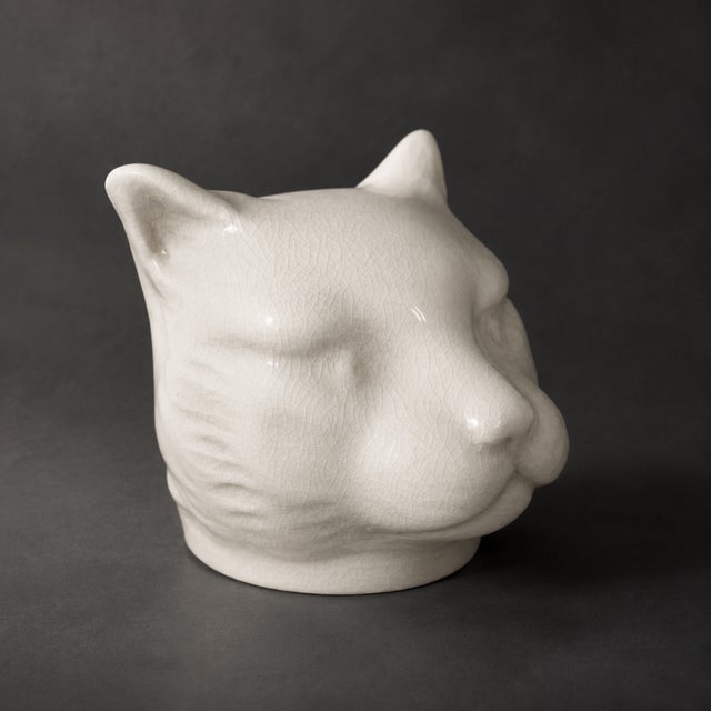 An unusual and highly decorative art deco ceramic piggy bank in the form of a stylized panther head, produced by l&v ceram...