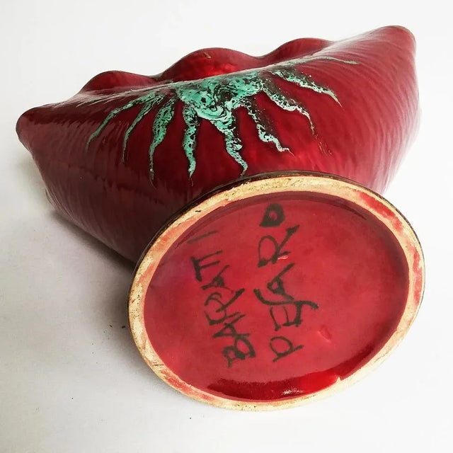 This fan-shaped vase features sun decoration on a red background. It was manufactured by Baratti, Pesaro.