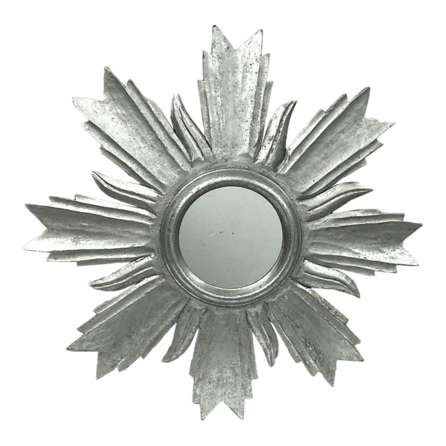 Mid-20th Century Sunburst Mirror crafted from carved wood and finished in silvered patina. The design radiates from a...