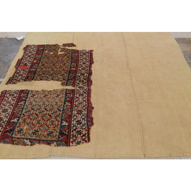 Hand-knotted in wool and originating in Turkey, this is a 7x7 vintage fragment rug resting calmly atop a beige flatweave....