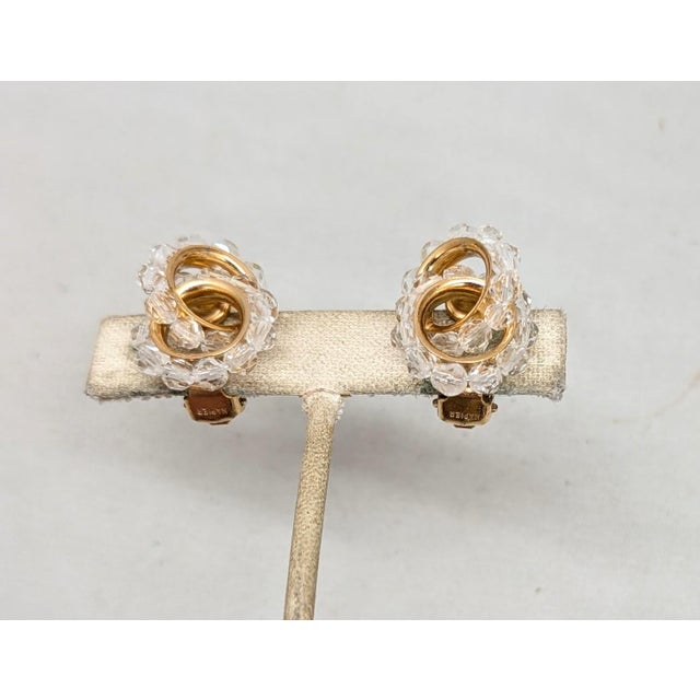 1962 goldtone cut faceted glass beads in the shape of a figure 8 clip earrings. Marked "NAPIER PAT. PEND." on the clips....