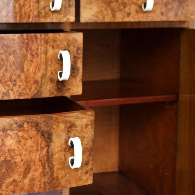 An Art Deco Sideboard. Burr Walnut and figured Walnut veneered on solid Mahogany. Original white and black Bakelite...