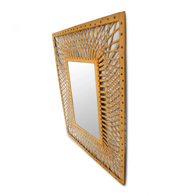 Vintage iron weave mirror featuring an intricately hand-forged lattice that radiates outward from a riveted inner frame....