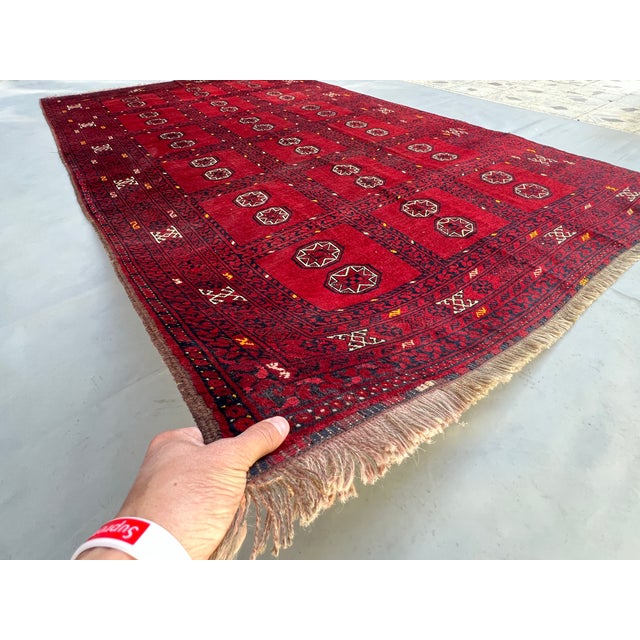 A rare vintage Afghan Turkmen room rug in the prized "garden compartment" format — 18 rectangular panels organized in...