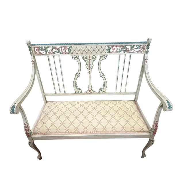 Charming hand‑painted Gustavian‑style two‑seat settee in a cream ground with painterly blue, red, and green accents....
