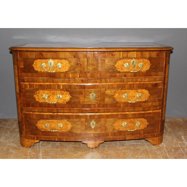 A Louis XIV commode in marquetry of walnut, maple, and cherry wood, opening with four drawers in three rows, with a...