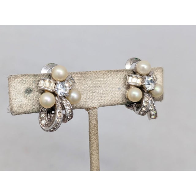 1950s rhodium plated faux-pearls with round and baguette clear rhinestones clip earrings. Marked "PENNINO" on the clips....
