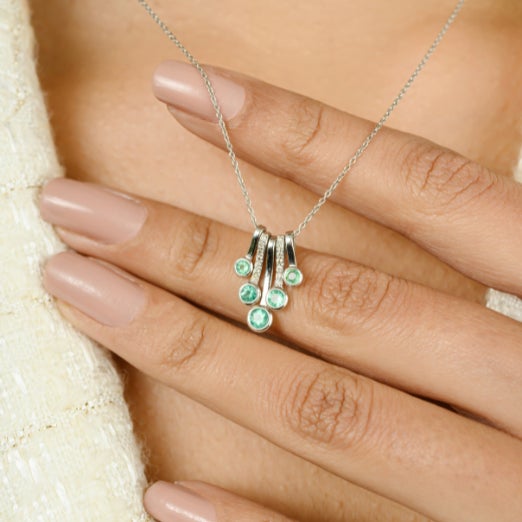 0.5 Carat Round Cut Emerald Dangling Pendant Necklace with Diamonds in 18k White Gold. This stunning piece of jewelry...