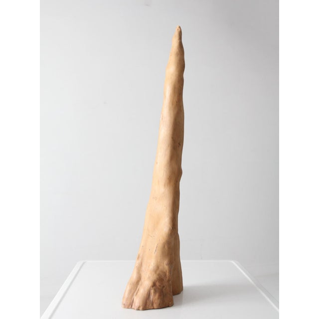 This natural sculptural wood form features an elongated silhouette, flowing contours, and a naturally weathered surface...