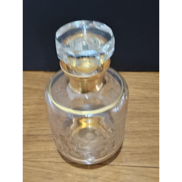 The carafe made of lead glass, richly decorated with hand-etched floral motifs and accents of a gilded frame, is the...