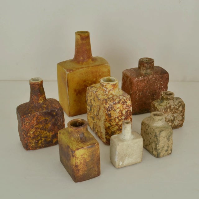 Set of eight Mid-Century Modern square studio pottery vases glazed in ocher and natural earth tones hand formed and in...
