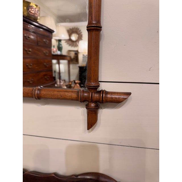 This is a French antique or vintage faux-bamboo wall mirror with a hand-carved wood frame. The frame has been shaped and...