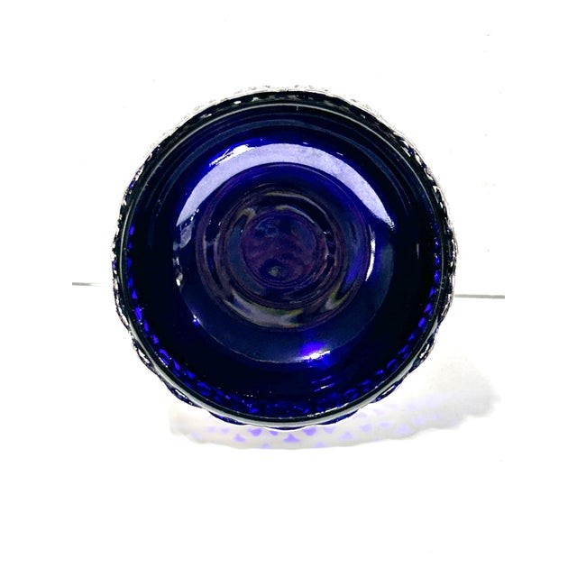 An elegant antique silver plate pedestal bowl featuring an ornate pierced gallery rim and vivid cobalt blue glass liner....