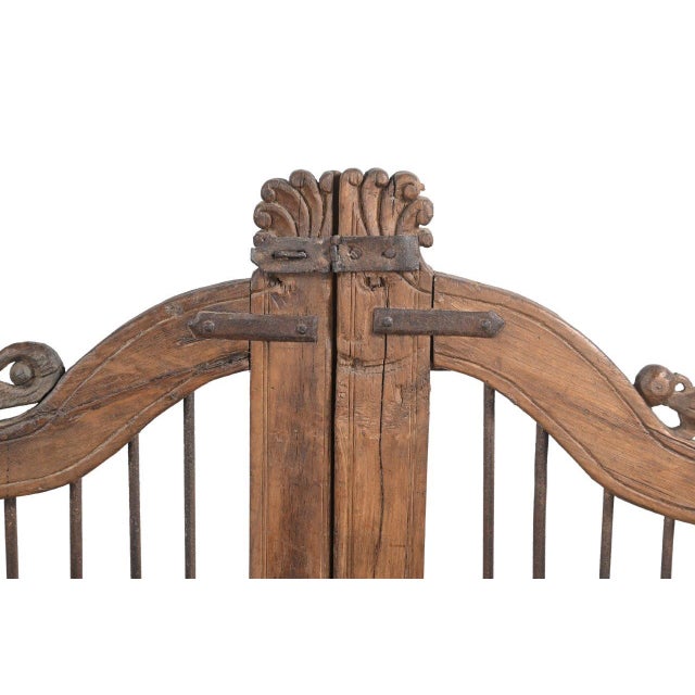 This Vintage Indian Teakwood Garden Gate or "Dog Door" features a graceful arched crest, decorative carved finials, and...