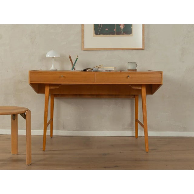 A wonderful freestanding desk from the 1950s. High-quality ash veneer cabinet with two drawers, a storage compartment, and...
