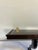 A classic vintage wall shelf by Bombay Company featuring a warm mahogany finish and a graceful curved support bracket....