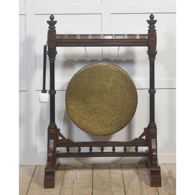 A striking late 19th-century Gothic Revival freestanding gong, mounted in an elaborately carved walnut frame of...
