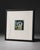 Modern framed still life painting featuring mussels on a white plate. The artwork has a clean, minimal composition with...