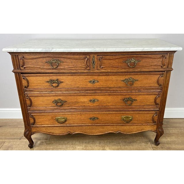 This elegant Antique French chest of drawers combines timeless craftsmanship with practical storage, making it an...