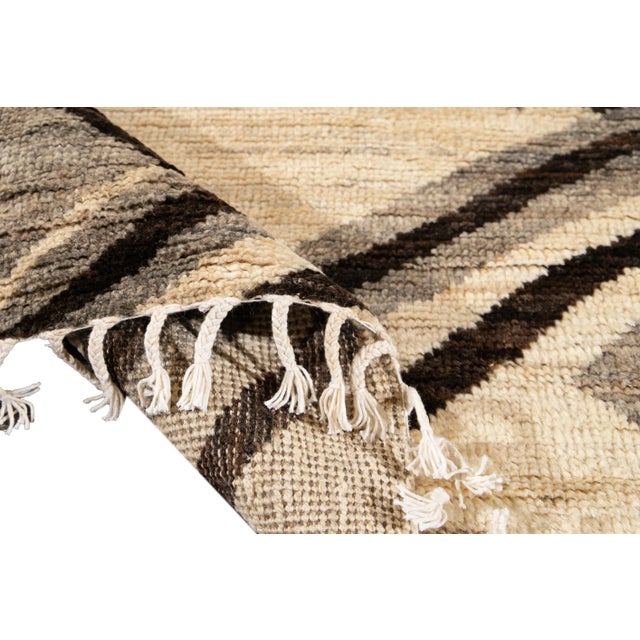 Beautiful Moroccan-style hand-knotted wool rug with a beige field. This Rug has accents of gray and brown in a gorgeous...