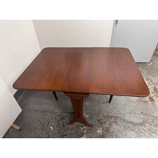 Design Plus Gallery presents a Vintage Federal Style Mahogany Drop-Leaf Gateleg Dining Table. This traditional table...
