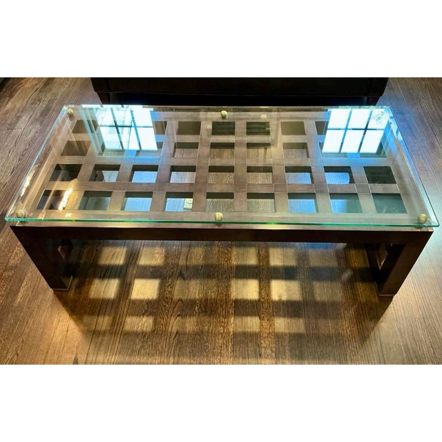 This is a large substantial Theodore Alexander coffee table with a thick beveled glass top on a sculptural gridwork wood...