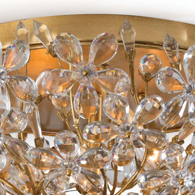 Delicately crafted crystal flowers suspended by gold frame, gives this flush mount a strikingly romantic feel. The hand-...