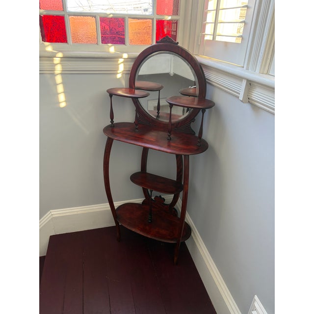 Victorian mahogany étagère with an oval mirror and staggered shelves. This design is characteristic of the late...