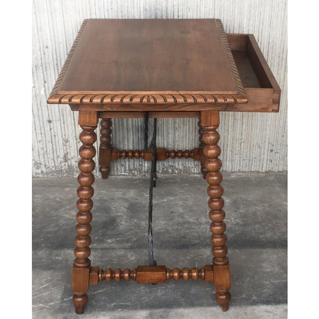 19th century Spanish farm table with iron stretchers, hand carved top and drawer. An unusual form with nice shiny patina....
