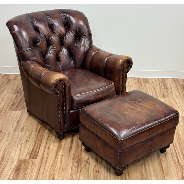 Classic vintage tufted wingback chair upholstered in a warm brown leather. Features deep button tufting on the backrest...