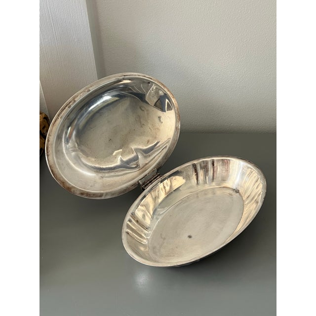 Vintage silver plate silent butler with a lion etched in the top. It bears a wooden handle.