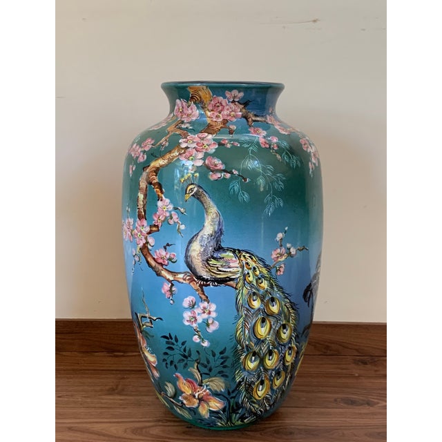 About Featuring a painted chinesse scenes with exotic fruits, animals, ocean, and huts. The baluster vase was made by the...