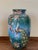 About Featuring a painted chinesse scenes with exotic fruits, animals, ocean, and huts. The baluster vase was made by the...