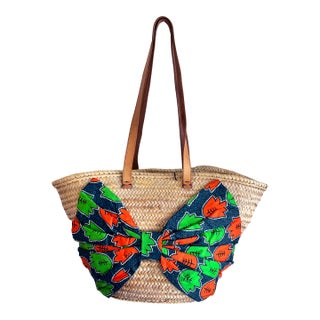 A Giselle Handwoven Straw Basket / Tote Featuring a Large Bow Made From Colorful Print and Brown Leather Shoulder Straps. For Sale
