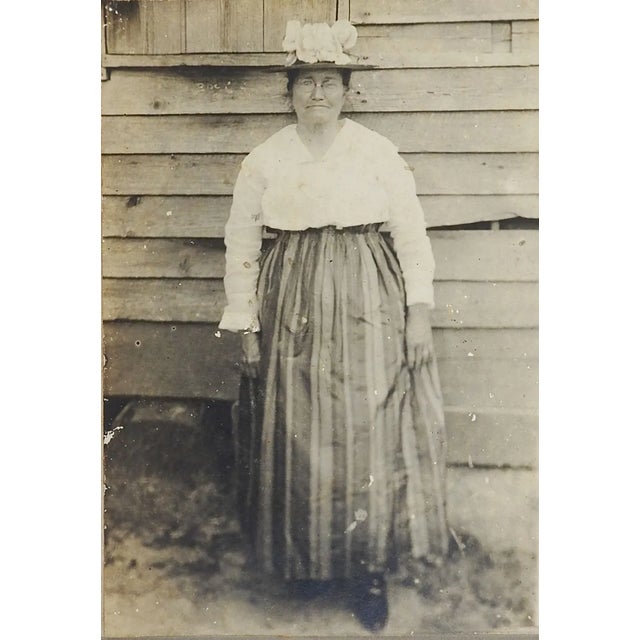 Antique circa 1900 silver gelatin photograph of a woman wearing glasses, smart hat and striped skirt. Unframed, mounted on...