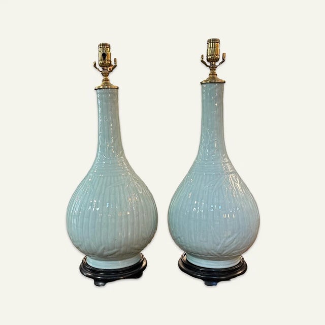 This pair of large pear-shaped celadon lamps with black bases has molded bamboo motif decoration. The lamps are being sold...