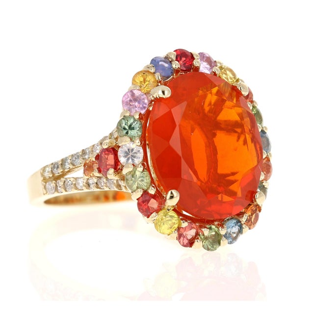 6.29 Carat Fire Opal Sapphire Diamond Yellow Gold Cocktail Ring This ring features a 4.40 carat Oval Cut Fire Opal at its...