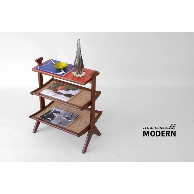 Very rare vintage 3-tier magazine table from the 1950s. Top shelf has a flat surface covered in red laminate and the two...