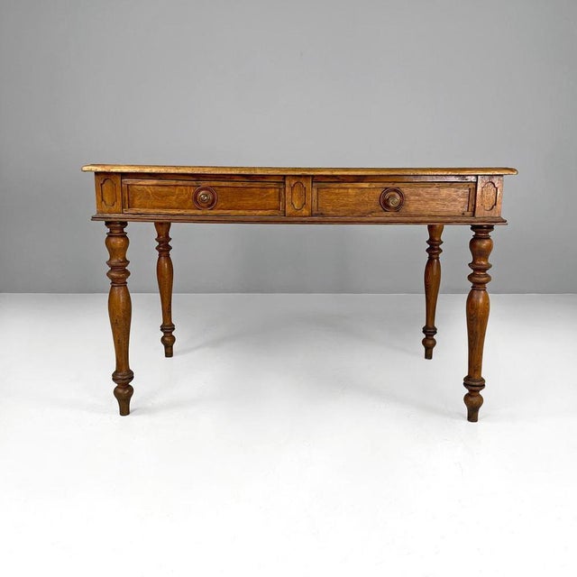 Dining table with rectangular top made entirely of wood. with two drawers with round wooden knobs, it has decorations on...