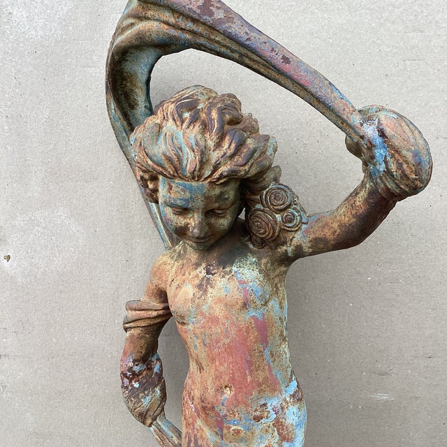 The Antique Iron Garden Statue features a beautiful design of a Dancing Nymph with Scarf, intricately crafted from iron....